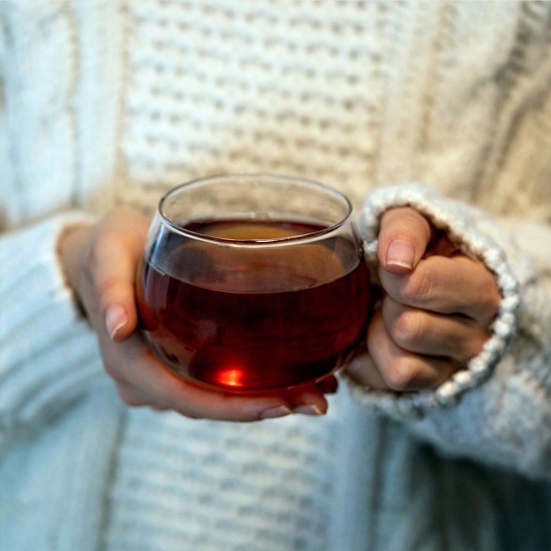 Person holding a cup of tea