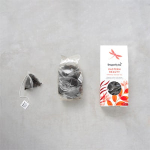 Tea Packaging layout of the Dragonfly Eastern Beauty Tea. Showing the Plant-based Plastic-free Pyramid Tea Bag, the Biodegradale Inner Pouch and the Recyclable Cardboard Box. 