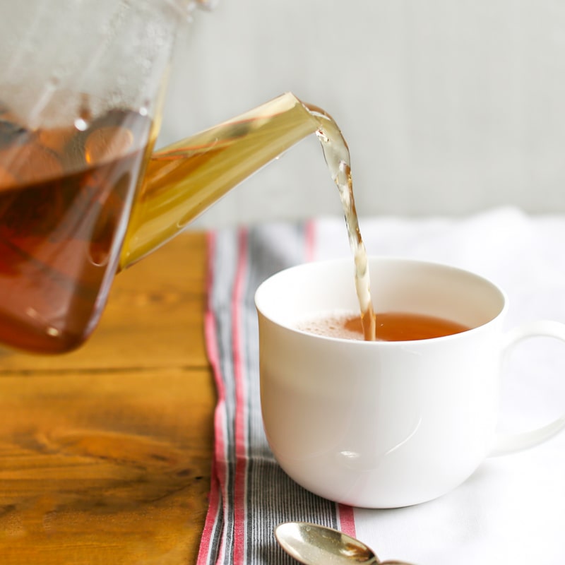 Pouring rooibos tea into a cup